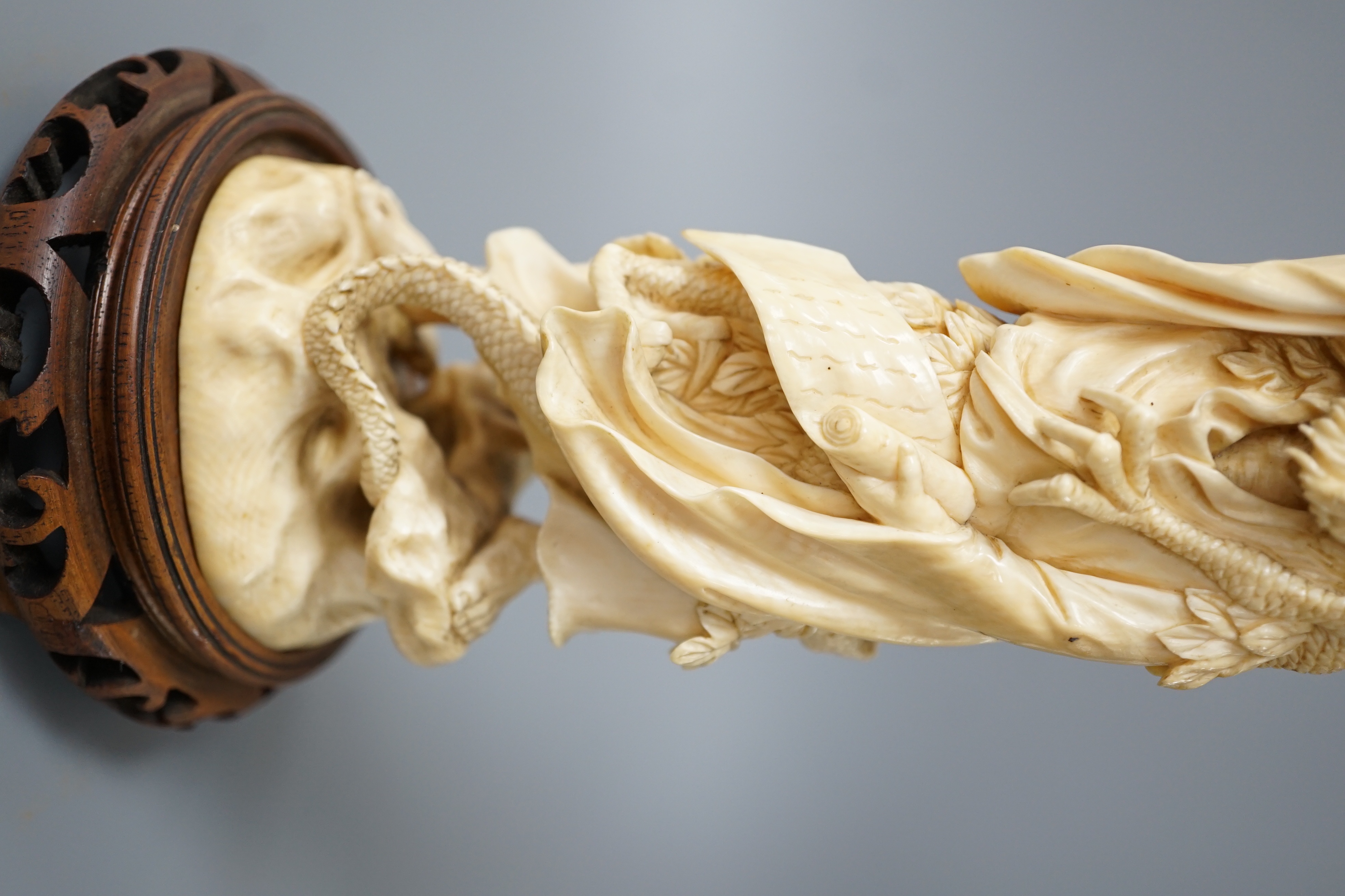 A Japanese ivory okimono of Shoshi Sennin and a dragon, early 20th century, signed, associated wood stand, 24cm excl stand